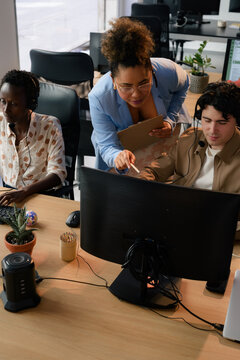 Supervisor helping call center workers during calls 
