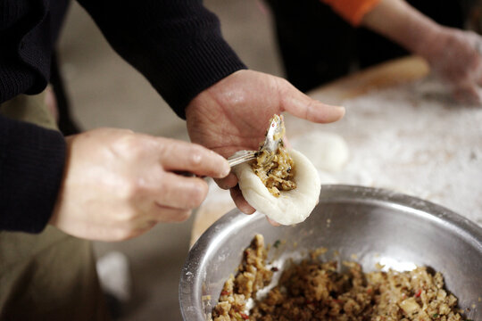 Closeup of glutinous rice cakes filled with filling being made