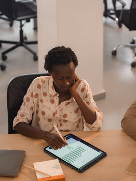 Woman taking notes using tablet computer during meeting 