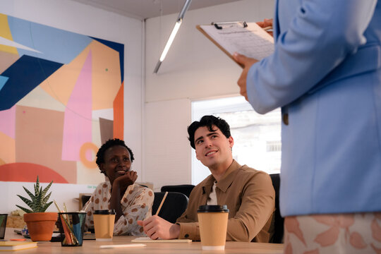 Engaged people listening to speaker during meeting at office 