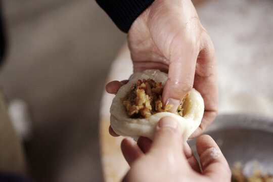 Closeup of glutinous rice cakes filled with filling being made