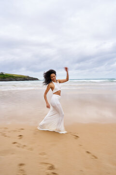 Woman dancing on beach embracing joy and freedom