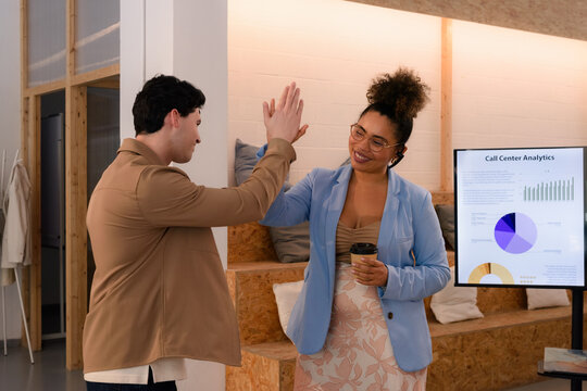 Colleagues are giving high five to each other at office 