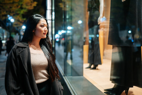 Woman window shopping in Tokyo at night