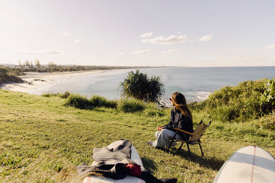 UGC Woman relaxing beside surfboard above Cabarita Beach, Australia
