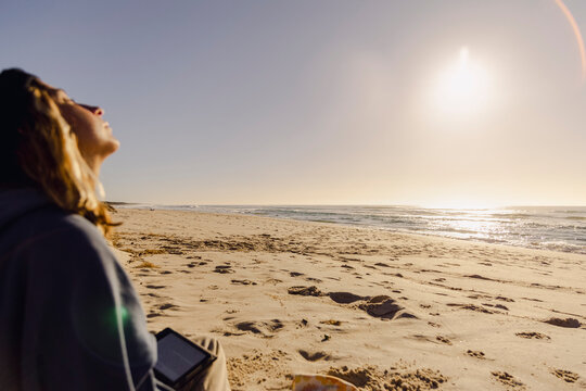 UGC Woman leaning into warm morning sun on quiet autumn beach