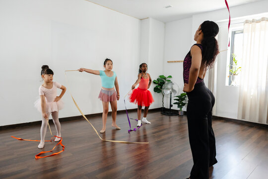 Diverse children learning rhythmic gymnastics dance movements