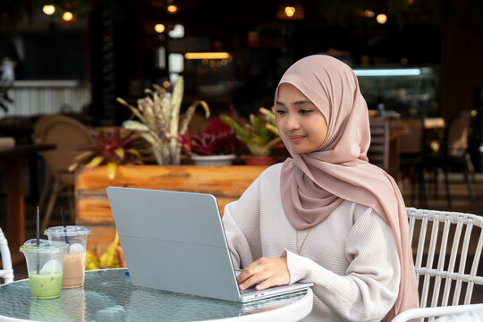 Woman using laptop outdoor with matcha tea drink