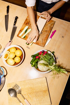 Chef slicing zucchini for intimate home dinner preparation with flash