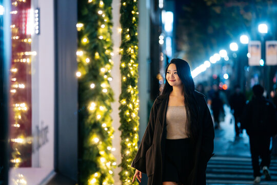 Japanese woman walking in Tokyo night street lights