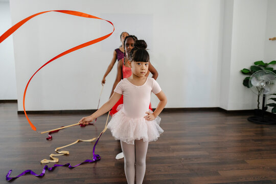 Young girl practicing rhythmic gymnastics with colorful ribbons