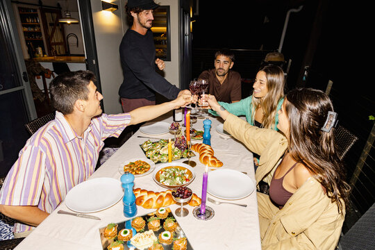 Friends toasting wine at outdoor catered dinner party