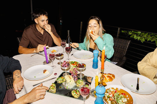 Friends eating and sharing appetizers at outdoor dinner party