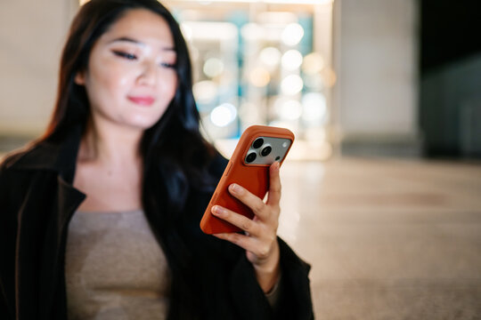 Japanese woman using smartphone at night in Tokyo