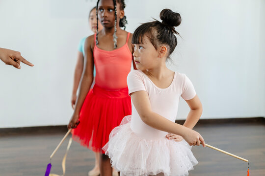 Diverse girls learning rhythmic gymnastics with ribbons