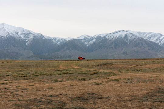 Red Off-Road Vehicle Driving on Remote Wilderness.