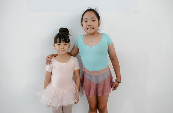 Two young asian girls posing, showing friendship and ballet training