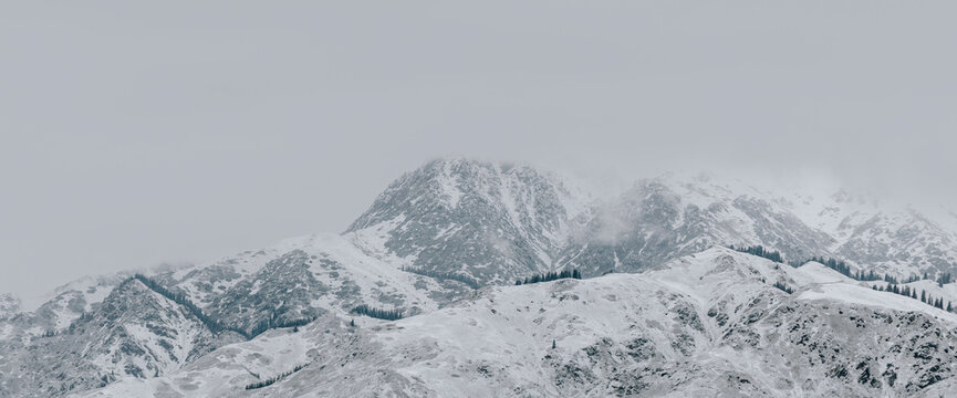Misty Winter Mountains in Ink Tones: A Cloud-Veiled Landscape.