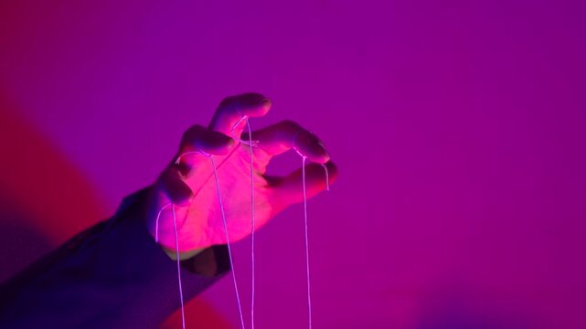 Hand with Puppet Strings in Neon Pink Light &mdash; Control and Manipulation Concept