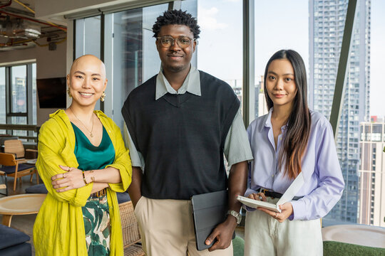 Group of Three Professionals in Modern Office Setting During Daytime