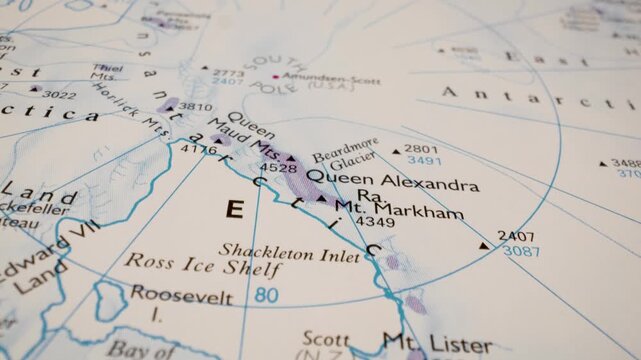 south pole, antarctica: gliding view over an atlas map showing the polar region