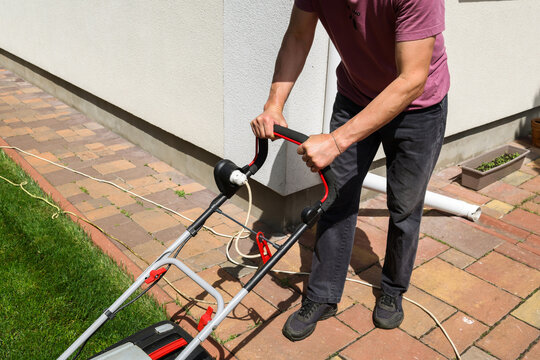 A man mows the lawn in the yard.