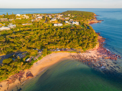 Hillside housesabove a small beach between rocky points