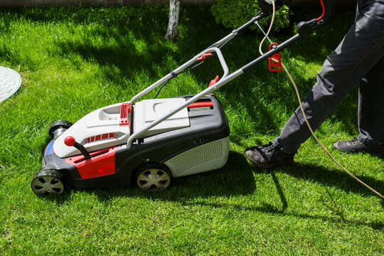 A man mows the lawn in the yard.