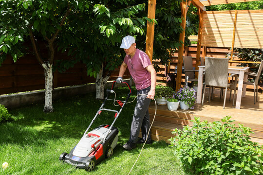 A man mows the lawn in the yard.