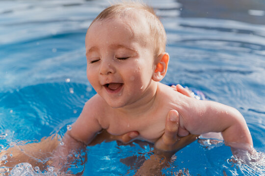 Baby enjoying swimming in pool experiencing joy