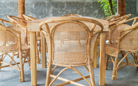 Cozy outdoor dining area with wooden table and wicker chairs on tropical villa patio