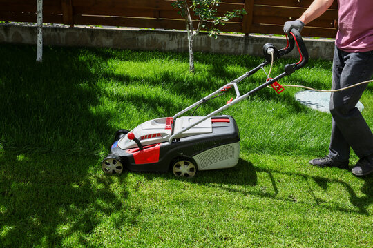 A man mows the lawn in the yard.