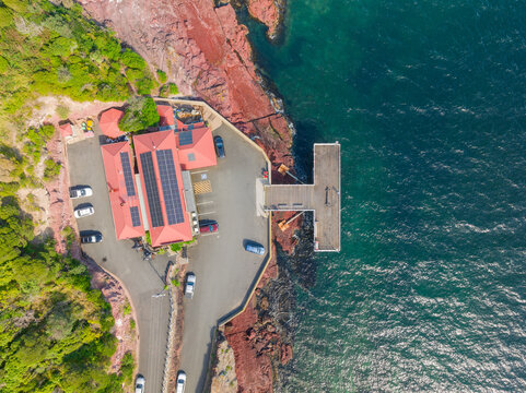 A T shaped coastal pier jutting out onto a deep blue ocean