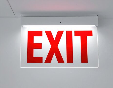 Illuminated red exit sign pointing way to safety