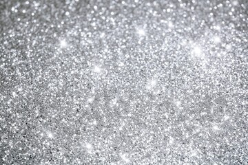 Fototapeta premium Shimmering silver glitter sparkles under bright light on a flat surface
