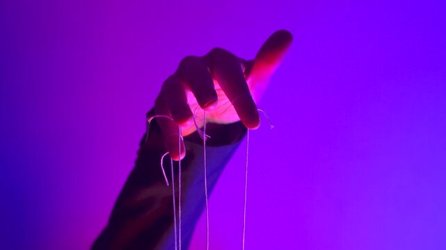 Hand with Puppet Strings in Neon Pink Light &mdash; Control and Manipulation Concept