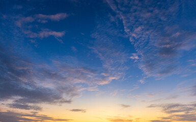 Fototapeta premium Beautiful Golden Sunset and Blue Sky with Clouds,A serene and picturesque view of a vibrant sunset with golden and warm light blending into a soft blue sky scattered with delicate clouds, perfect for 