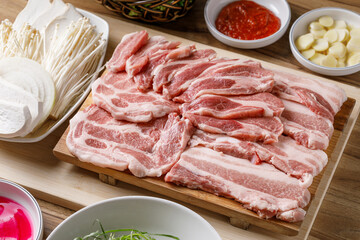 Fototapeta premium Fresh raw pork belly slices on a wooden cutting board