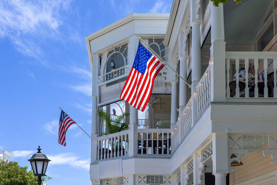 American flags hanging on a historic white building balcony in Key West Florida