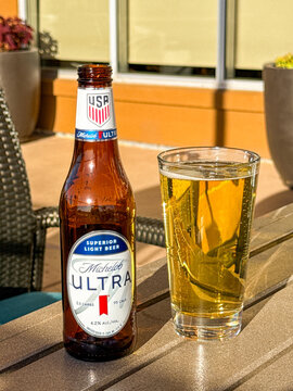 Page, Arizona, USA - 30 June 2026: Bottle of Michelob Ultra light lager beer and a full glass on a table on the terrace of a hotel.