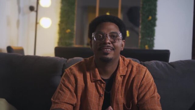 African american man with glasses smiling on the sofa