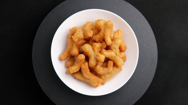 Deep fried dough stick,Chinese cruller or Chinese doughnut in white plate.It is popularly eaten for breakfast.Top view.