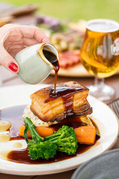 Delicious Gourmet Pork Belly Served With Vibrant Vegetables and Rich Sauce