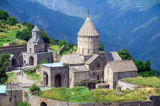 Mountain Tatev monastery complex with arched entrances and conical roof