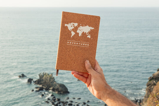 Hand holding adventures notebook dreaming of travel and digital detox