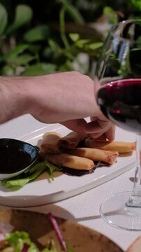 Traditional fried spring rolls on a table restaurant hand 