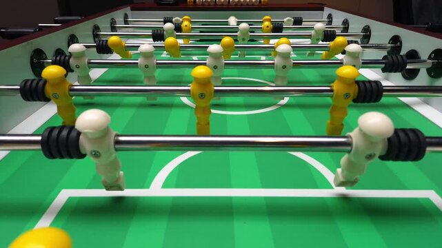 Foosball Table with Yellow and White Players Ready for Match