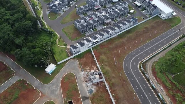 Aerial view of a newly developed housing project with rows of modern houses and infrastructure development
