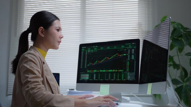 Female stock trader analyzing cryptocurrency market data on computer monitors for investment strategy