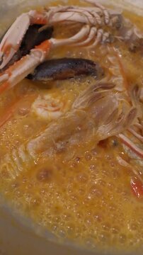 Chef cooks shrimps mussels sea food and garlic in a frying pan.
